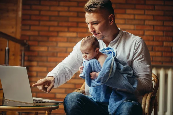 Pai com bebê recém-nascido trabalhando a partir de casa usando laptop — Fotografia de Stock