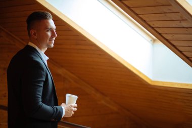 Evde kahve içme ve uzak seyir yakışıklı işadamı