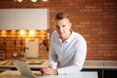 kameraya gülümseyen kahve tutan ofisinde oturan girişimci