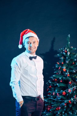 Yakışıklı erkek ayakta Noel ağacı üzerinde