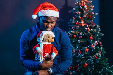 Noel hediyesi elinde tutan çekici gülümseme ile Afro Amerikan adam