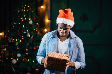 Noel hediyesi elinde tutan çekici gülümseme ile Afro Amerikan adam