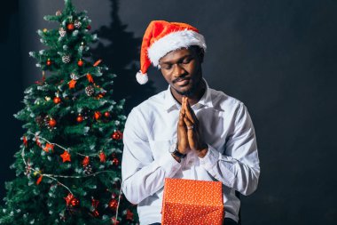 Noel hediyesi elinde tutan çekici gülümseme ile Afro Amerikan adam