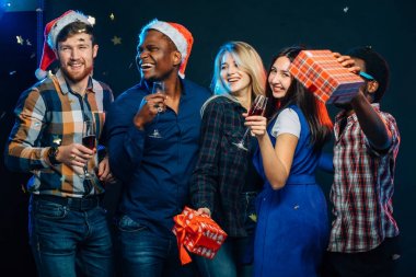 Yeni yıl birlikte kutluyor. Noel Baba şapkaları içinde güzel gençlerin grup