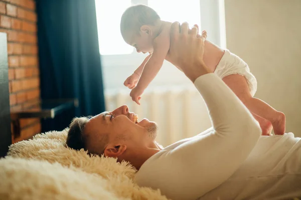 Şirin bebek kızı yatakta yatan baba — Stok fotoğraf
