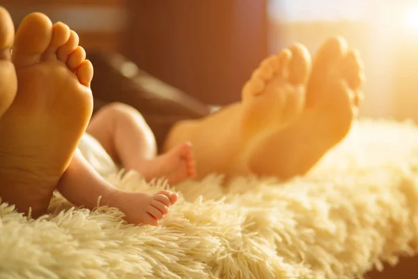 家族の焦点を彼らの feets のベッドの上に敷設します。母、父、新生児の赤ちゃんの息子 — ストック写真