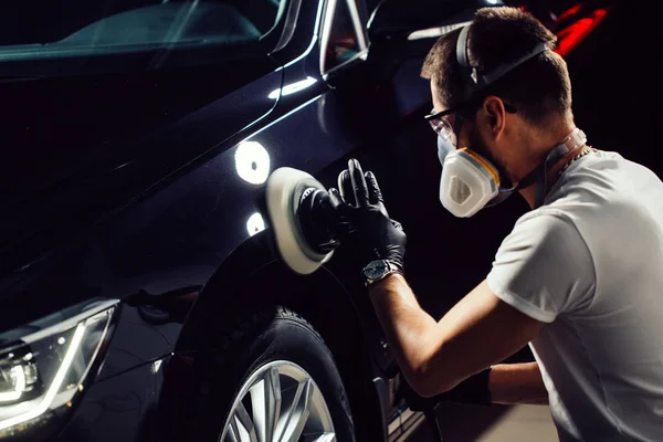 Détail de voiture - homme avec polisseuse orbitale dans l'atelier de réparation automobile. Concentration sélective . — Photo