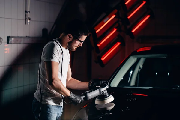 Auto detaillering - man met orbitale polijstmachine in auto reparatiewerkplaats. Selectieve aandacht. — Stockfoto