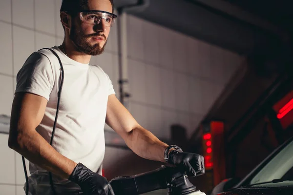 Auto podrobně - muž s orbitální leštička v automatické opravna. Selektivní fokus. — Stock fotografie