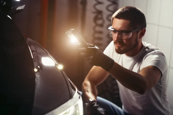 Mann kontrolliert Polieren mit Taschenlampe — Stockfoto