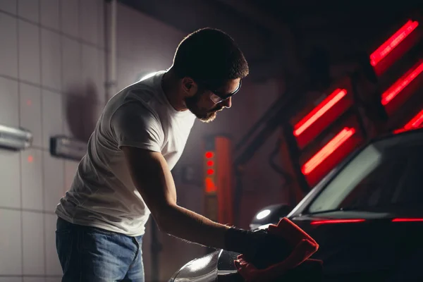 Homem limpeza carro com pano de microfibra, carro detalhando ou valeting conceito — Fotografia de Stock