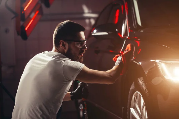 Mann reinigt Auto mit Mikrofasertuch, Auto Detaillierung oder Valeting-Konzept — Stockfoto