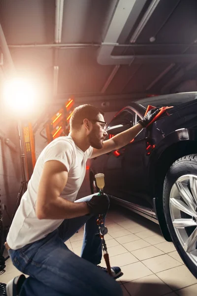 Homem limpeza carro com pano de microfibra, carro detalhando ou valeting conceito — Fotografia de Stock