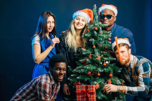 Amigos se burla de día de fiesta de Navidad con árbol de Navidad — Foto de Stock
