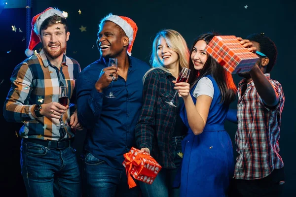 Yeni yıl birlikte kutluyor. Noel Baba şapkaları içinde güzel gençlerin grup