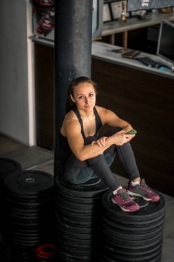 spor salonunda Smartphone kullanan kadın uygun