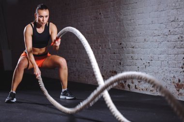 Atletik kadın savaş ip spor salonunda yapıyor