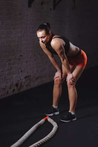 Αθλήτρια στέκεται στο γυμναστήριο μετά από την προπόνηση σχοινί μάχη και κοιτάζοντας προς τα κάτω — Φωτογραφία Αρχείου