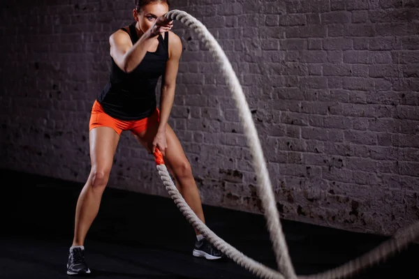 Entrenamiento de mujer con cuerda de batalla en gimnasio cross fit — Foto de Stock