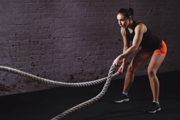 Sesión de cuerdas de batalla. Atractivo entrenamiento de deportista joven en forma y tonificado en el gimnasio — Foto de Stock