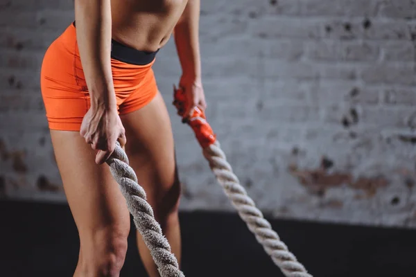 Mulher poderosa fazer treino com cordas de batalha no ginásio — Fotografia de Stock