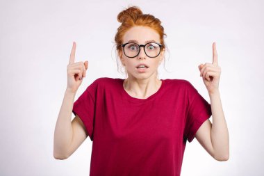 Kız gösteren kopya alanı parmak beyaz arka plan ile şaşırttı. yukarı dönük kız