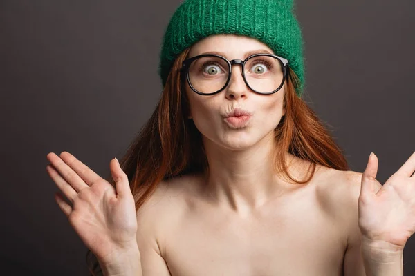 Ingwerfrau mit Brille und grünem Hut schmollt ihre Lippen bereit zum Küssen — Stockfoto