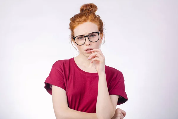 Woman with finger near mouth, looking at camera on white background — Stock Photo, Image