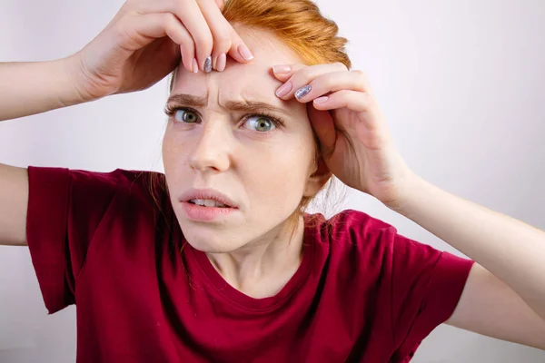 Mulher ruiva apertando suas espinhas, removendo espinha de seu rosto — Fotografia de Stock