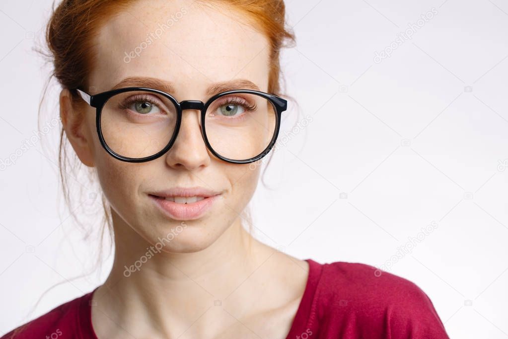 portrait of attractive young redhead woman smiling with glasses