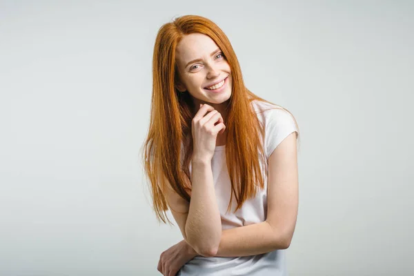 Menina sardenta com nó de cabelo se divertindo dentro de casa e olhando para a câmera com sorriso — Fotografia de Stock