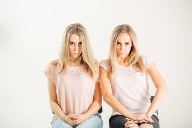 Beyaz bir arka plan üzerinde genç ciddi kız ikiz