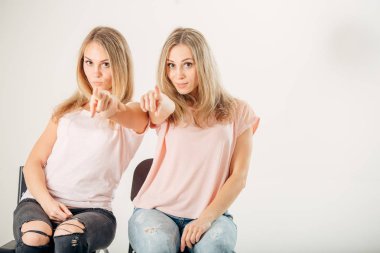 Beyaz arka plan üzerinde gösteren iki attrative kız ikiz