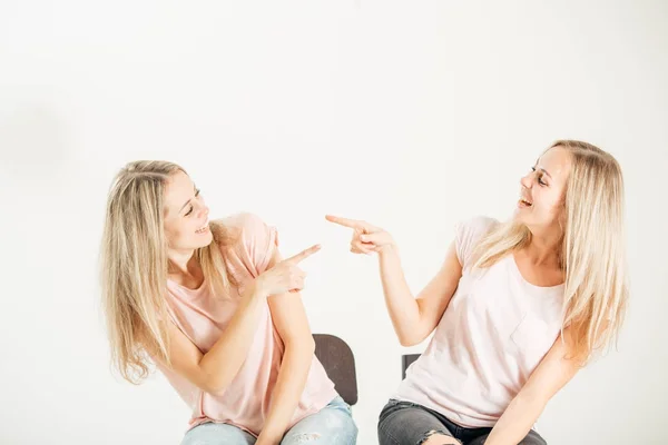 Two attrative sisters twins pointing over white background — Stock Photo, Image