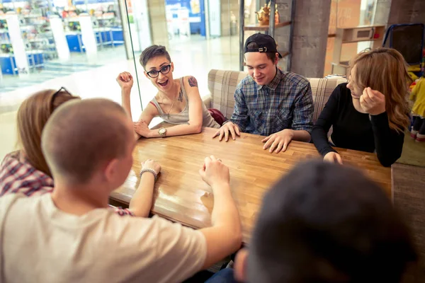 Grupo de estudantes sentados em um bar de café olhando uns para os outros — Fotografia de Stock