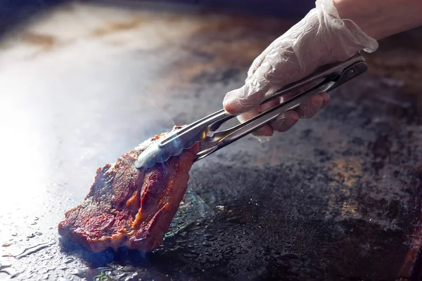 夹持煎肉。厨师正在准备猪肉 — 图库照片