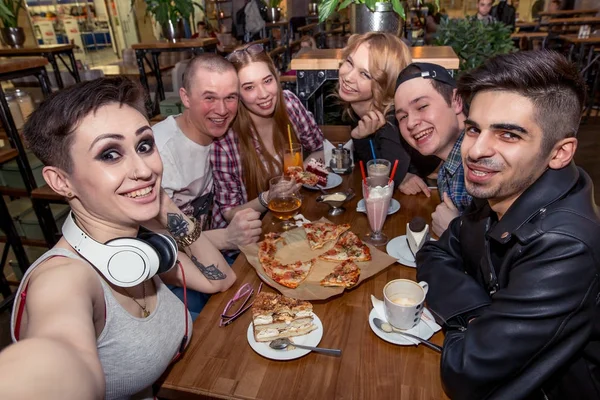 Groep multiraciale jongeren nemen van een selfie tijdens het eten van pizza — Stockfoto