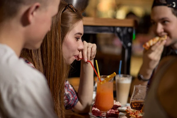 Fiatal nő iszik turmix barátok kávézóban ülve — Stock Fotó