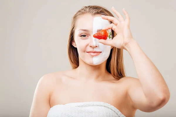 Mladá krásná žena s obličejové masky a jahody, lázeňská léčba — Stock fotografie