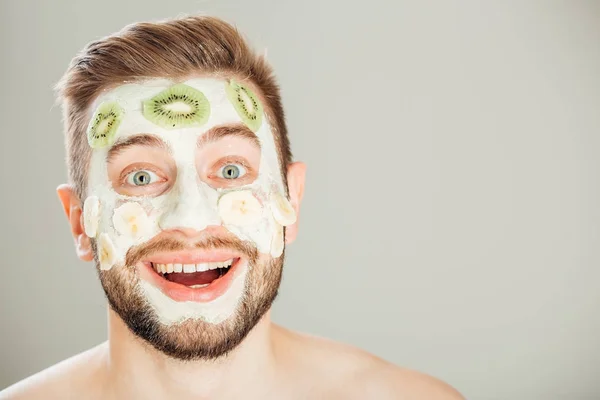 Hombre con máscara cosmética en la cara, fondo gris — Foto de Stock