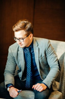 adam görüşme için hazırlanıyor. O takım, iskemle, salonda oturmuş bekliyor