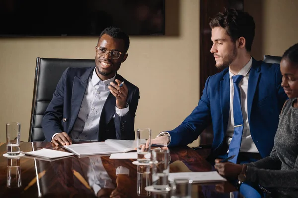 black male boss talking to business team in conference room