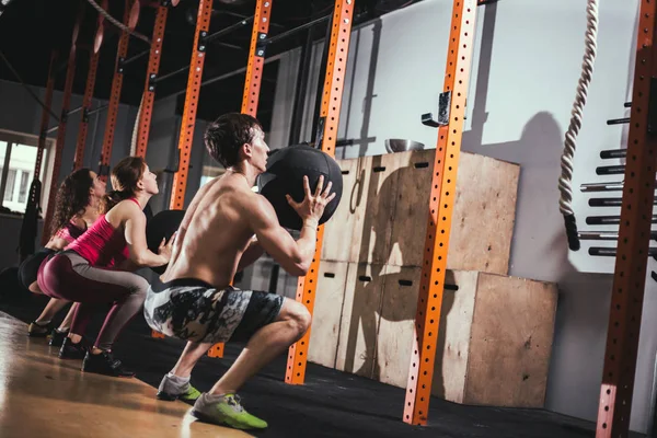 Concepto de ajuste, deporte y ejercicio: personas con pelotas de medicina que entrenan en el gimnasio — Foto de Stock