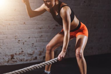 Güçlü kadın birlikte savaş ipler spor salonunda egzersiz yapın