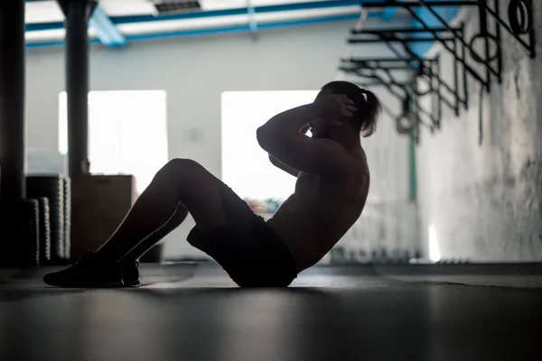 Kaslı adam yapıyor egzersiz silüeti egzersiz kadar oturmak — Stok fotoğraf