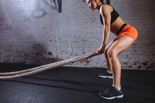 Atletisk kvinna gör slaget rep övningar på gym — Stockfoto