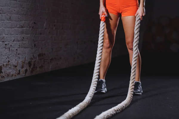 Mladá žena chystá cvičit s bitva lana v cross fit tělocvična — Stock fotografie