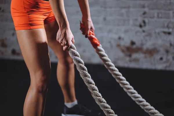 Mulher treinando com corda de batalha em cross fit ginásio — Fotografia de Stock