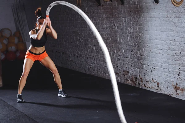 Mulher fazendo exercício cross fit com uma corda de batalha — Fotografia de Stock