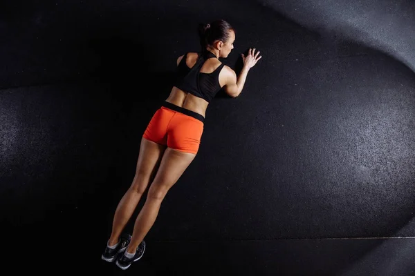 Mooie vrouw in sportkleding plank terwijl trainnig bij cross fit gym doen — Stockfoto